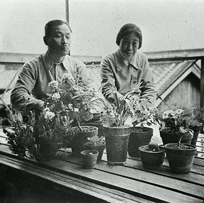 鉢植を前に微笑む夫婦